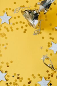 Golden trophy on yellow background with star confetti, symbolizing success and achievement.